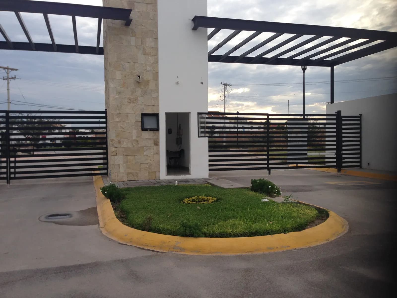 Glorieta con pasto en el acceso de la privada